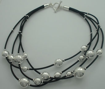 Leather necklace with balls in decrease, round dividers of silver and brooch of T