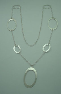 Necklace of 3 smooth big ovals and four hammered small ovals linked with chain.