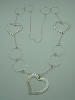 Necklace of 3 smooth big hearts and 8 rings of thin wire, linked with chain.