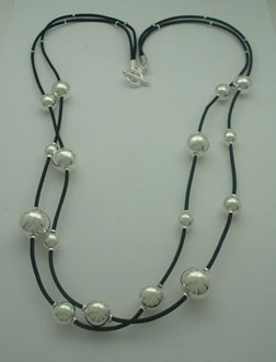 Necklace of double rubber with balls in decrease of 80cm of length and brooch of T