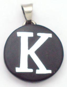 Pendant of black plastic with letter K